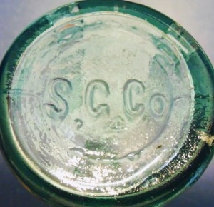 Southern Glass Works: S.G.CO. mark on base of aqua colored glass antique John J. Smith bottle, made in Louisville Kentucky in the late 19th century. . The small "4" is a mold number.