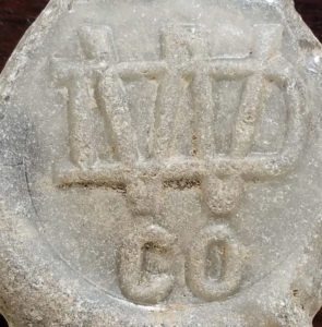 WDCO monogram, as it appears on beach glass (bottle base). Photo courtesy of Natalie Radosevic.