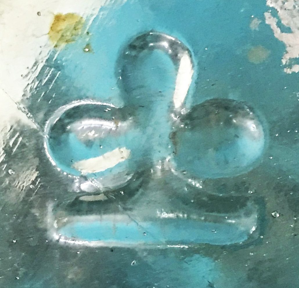 Clover-like logo seen on base of pharmacy bottle, made by Hermann Heye Glasfabrik, Germany (photo courtesy Lynne Wertz)
