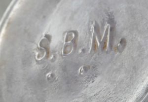 S.B.M. mark on the base of a light amethyst (sun-colored) cylindrical liquor bottle. (Photo courtesy E. Rex)