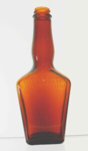 Liqueur bottle with "Federal Law Forbids Sale or Reuse of this Bottle" on face, made by Owens-Illinois Glass Company in 1957.