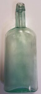 "Ginger oval" type medicine bottle made by Southern Glass Company, of Louisville, Kentucky, marked "S G Co" in a circle on base. This bottle measures 7 and 1/4th inches tall. The bottle dates from the late 1870s into the early 1880s.