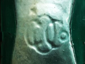 O G CO (monogram), used by Ottawa Glass Company of Ottawa, Illinois. This pic shows the mark on the base of an aqua "Coffin" or "Shoofly" type whiskey flask.