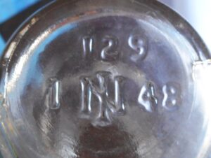 IN or NI monogram on base of clear cylindrical bottle that held olives or capers. Photo courtesy of Elaine Rex. 