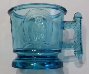 Blue glass "Owl & Horseshoe" child's mug attributed to Atterbury & Company of Pittsburgh, PA