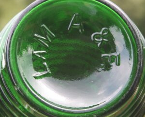 "LAM A & F" on base of green barrel-shaped bottle. 