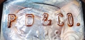 P D & Co. mark on the base of small amber rectangular medicine bottle made for Parke Davis & Company