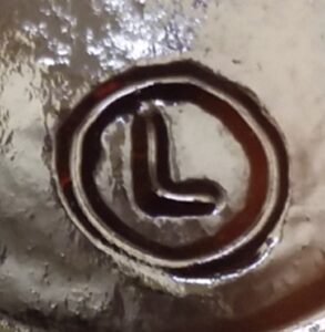 L inside a circle trademark on the base of a dark amber sauce bottle, recent manufacture - circa 2010s or later.