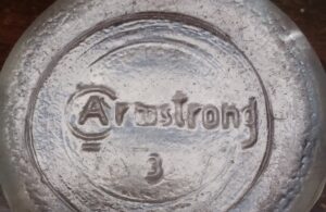 "Armstrong" on the base of a clear glass bottle - product of Armstrong Cork Company - Glass Division