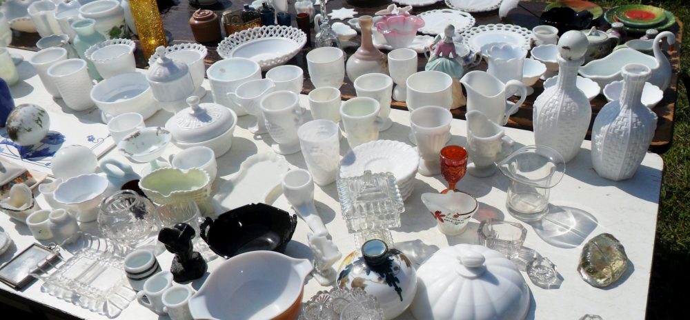 MILK GLASS - Assorted opaque glassware (and some other types of glass) for sale at an outdoor flea market in 2018.