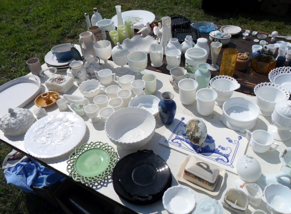 White Milk Glass (and some green) laid out on a table - old and vintage glassware for sale at a flea market in Kentucky. 