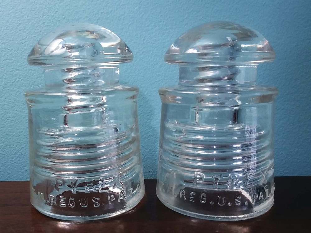 Two clear CD 128 insulators, made by Corning Glass Works. 