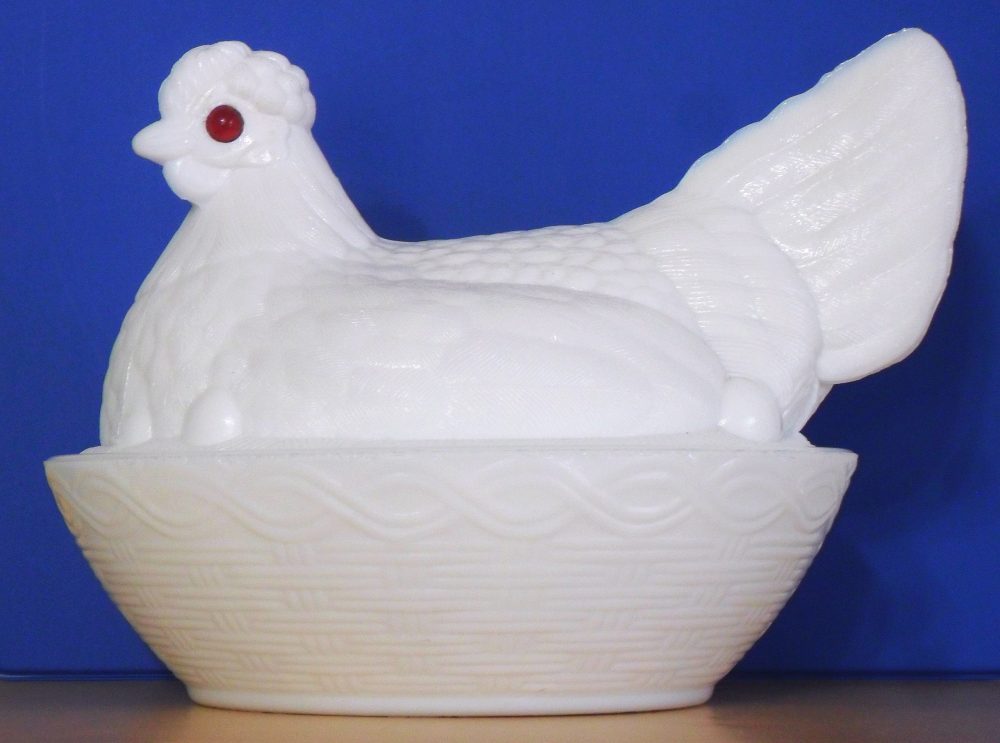 White milk glass - collectible antique "hen on nest" dish with red eyes, made by Atterbury & Company of Pittsburgh, circa 1880s-1890s.