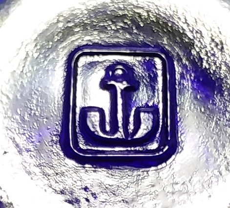 Anchor inside a rectangle mark used by Anchor Hocking. This appears on the bottom of a small cobalt blue dessert dish. 