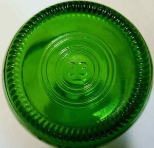 Mold number "33" on the base of an emerald green soda bottle made by Owens-Illinois, Inc. Millions of these types of "generic" non-returnable soda bottles have been made for many years. This particular bottle was made by Owens-Illinois in 1984, as indicated by markings along the lower heel of the bottle (not visible in photo). 