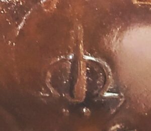 Greek letter Omega and image of bottle, as seen on base of Josh amber Hock wine bottle. (Photo courtesy of Josh Marquardt)