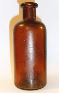 Small amber chemical /utility bottle, made by Fairmount Glass Works, marked "F G W" on base.