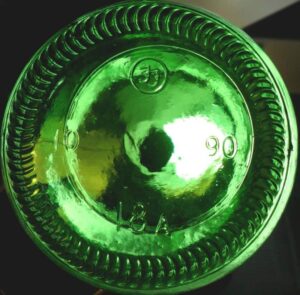 This is an example of a typical configuration seen on many bottles. This is an emerald green soda bottle made by Foster-Forbes in 1990. The "FF in a circle" was their logo, the "18A" is the mold number. The "10" is probably the plant location code. 