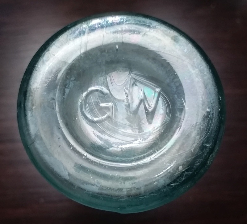 Great Western Glass Company - Base of cylindrical castor oil or medicine bottle (left in group photo, above) marked "G W". 