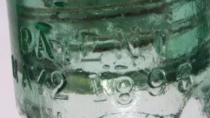 HEMINGRAY NO 9 glass pony insulator. The "1" in "1893" leans to the left in this particular "Stamp" mold. This example is in a light green glass.