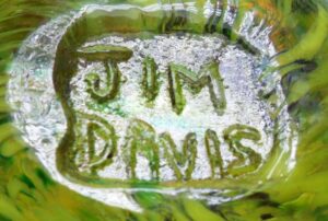 "JIM DAVIS" signature as impressed on base of yellow bird art glass paperweight