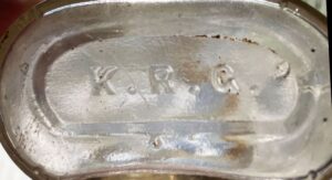 "K. R. G." on base of clear druggist bottle (Photo courtesy of Miles Burke)