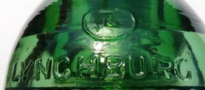 "L in an oval" and LYNCHBURG on green CD 154 style glass insulator made by Lynchburg Glass Corporation.