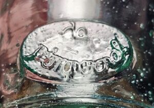 Unknown makers mark signature on side of handblown light green glass bottle with lots of bubbles in it. Poroguol? Porquonol?Porogonal? Porquool?