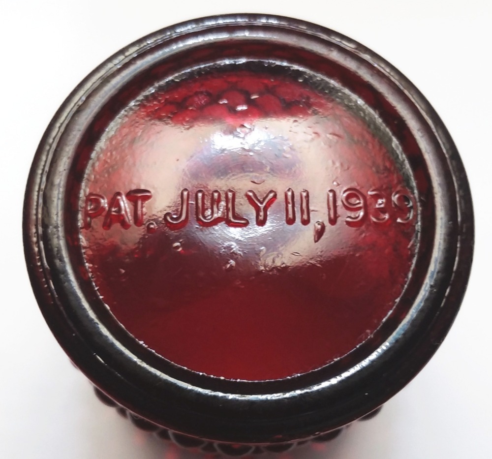 Pat. July 11, 1939 marked on the bottom of red amber candleholder made by Crescent Glass Company.