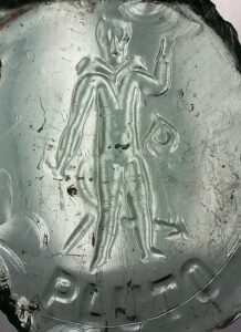 Base of Pluto spring water bottle showing Pluto or devil