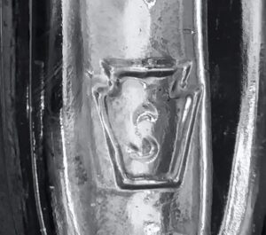 S in a keystone mark used by Seaboard Glass Bottle Company, here on the base of a small aftershave bottle.