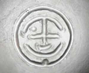 Unknown trademark / logo on bottom of matte frosted glass decor bottle - possibly made in Asia.