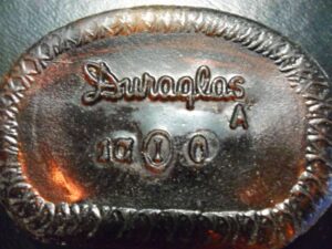 "DURAGLAS" trademark embossed on amber bottle base shard - indicating production of the Owens-Illinois Glass Company.