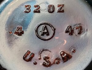 "A in a circle" on 32 ounce chemical bottle made by Armstrong Cork Company. The "47" is a date code for 1947. 