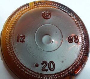 "B in a circle" mark on base of amber beer bottle made by Brockway Glass Company in 1983.