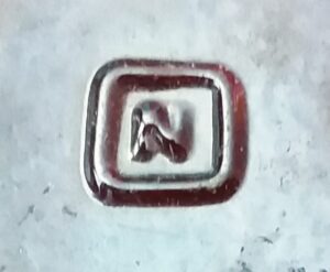 "N in a square" trademark used by Obear-Nester Glass Company - East St. Louis, Illinois - on base of amber bottle.