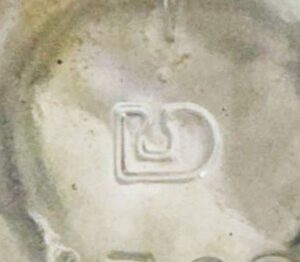 Stylized "D" mark standing for DOMGLAS based in Montreal, Canada. Domglas was a renaming of Dominion Glass Company. Mark used 1976-1989. Photo courtesy of Kayla Verge. 