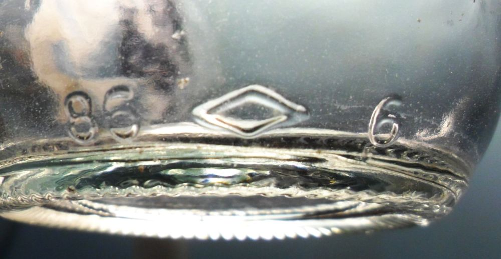 Diamond Glass Company, Royersford, PA soda bottle, made in 1986. Diamond mark on heel, with '86' date code positioned to left.