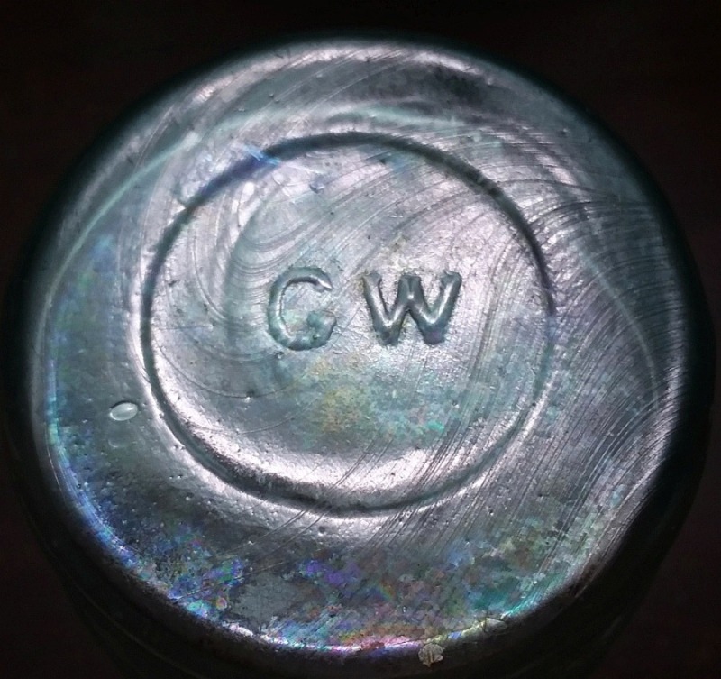 "G W" mark on base of aqua barrel style mustard jar, made by Great Western Glass Company of St. Louis, Missouri.