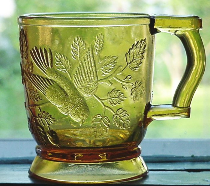 "Bird in Tree" or "Robin in Tree" pattern glass mug- Amber version made by Mosser Glass Company of Cambridge, Ohio.