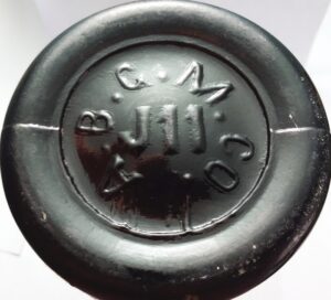 A.B.G.M.CO. mark on base of dark amber export beer bottle - Adolphus Busch Glass Manufacturing Company. The "J 11" is a mold identifier. 