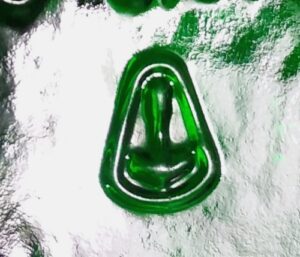 "Anchor or Pickaxe inside rounded triangle" mark used by BSN-Glasspack GmbH &amp; Co, Bernsdorf, Germany, Photo shows the mark on the bottom of a green glass Jägermeister bottle. 