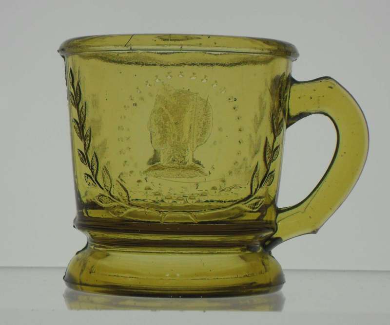 Ceres or Cameo (original pattern name Medallion) mug in yellow amber. This is a different mold than the example in black glass, shown below.