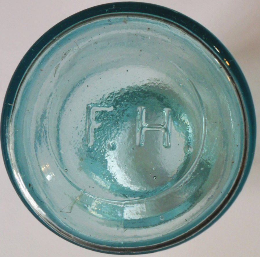 F.H. mark used by Frederick Heitz Glass Works, St. Louis. On base of wax sealer style fruit jar.