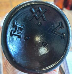 "H XX V" mark on base of dark amber blob top bottle made by either Høvik Glassverk,  Hurdal Glassverk, or Hadeland Glassverk, Norway. (Photo courtesy of Fadia Chipman).