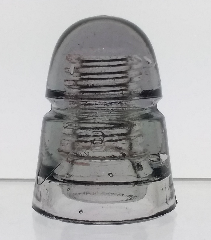 Light grayish-amethyst telegraph line insulator made by Brookfield Glass Company. This CD 145 "beehive" type has a "B" embossed on both the front and back, placed underneath the wire groove. 