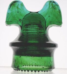 Hemingray CD 257 "Mickey Mouse" style electrical power line glass insulator in aqua-green glass with streaking of amber.