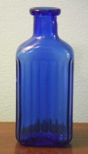 Cobalt blue Maryland Glass bottle, marked with "M inside a G" logo on base, probably intended as a poison bottle judging by the vertical ribbing.