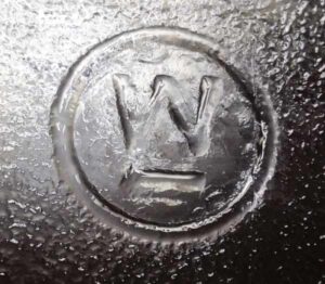 Underlined W inside circle trademark used by Westinghouse Electric Company - on base of glass refrigerator dish or loaf pan