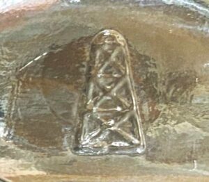 "Oil Derrick" mark as seen on base of clear druggist/medicine bottle made by Oil City Glass Company (Photo courtesy of David Davenport)